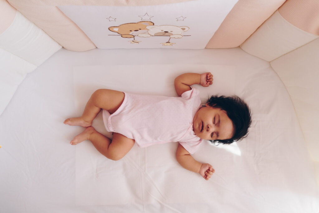 A baby sleeps in her crib.