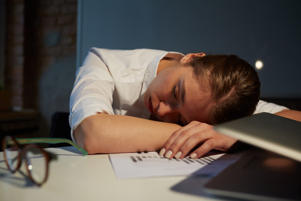 Exhausted woman sleeps at her desk