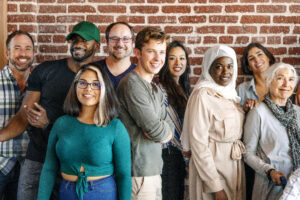 Group of diverse people standing in front of a brick wall