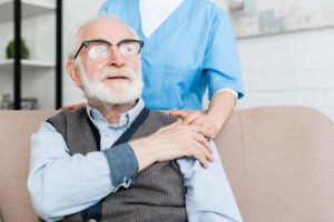 Doctor supporting elderly patient, putting hands on his shoulder