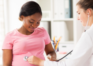 Young pregnant woman is speaking with her doctor.