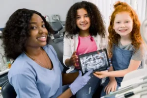 Dentist showing two children an x-ray of teeth